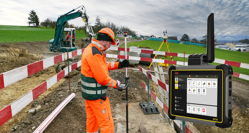 Obras de construcción civil con una excavadora pequeña y una estación total Leica. Empleado de construcción con el controlador de campo Leica iCON CC170. 